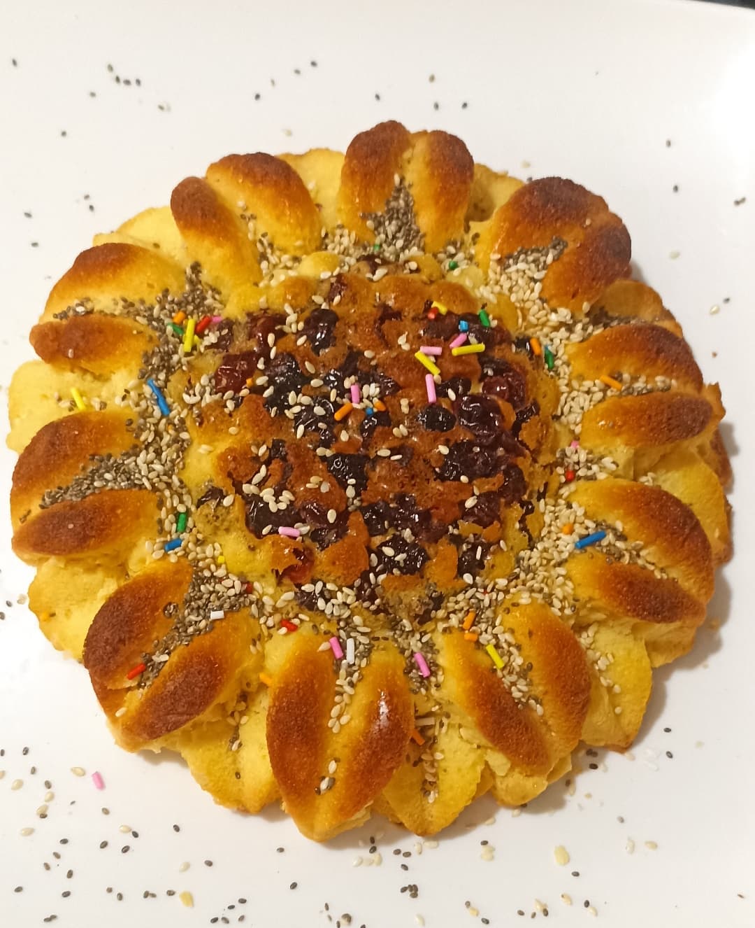 Ponqué artesanal en forma de girasol con uvas pasas, chía y ajonjolí
